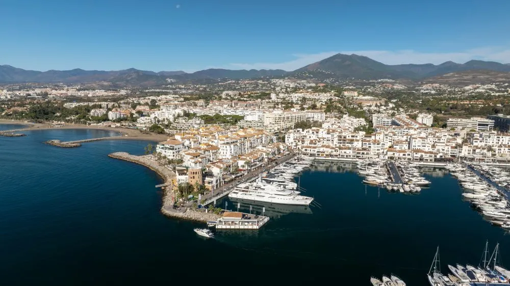 Aerial view of Puerto Banús marina with yachts, white buildings and La Concha mountain behind