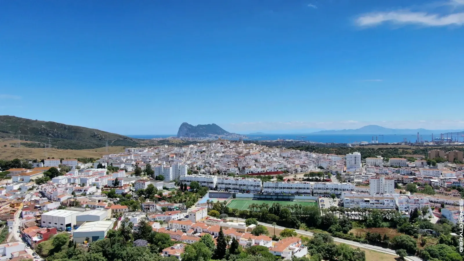 San Roque（San Roque）白色房屋的鸟瞰图，背景中可见直布罗陀岩及其后方的海湾