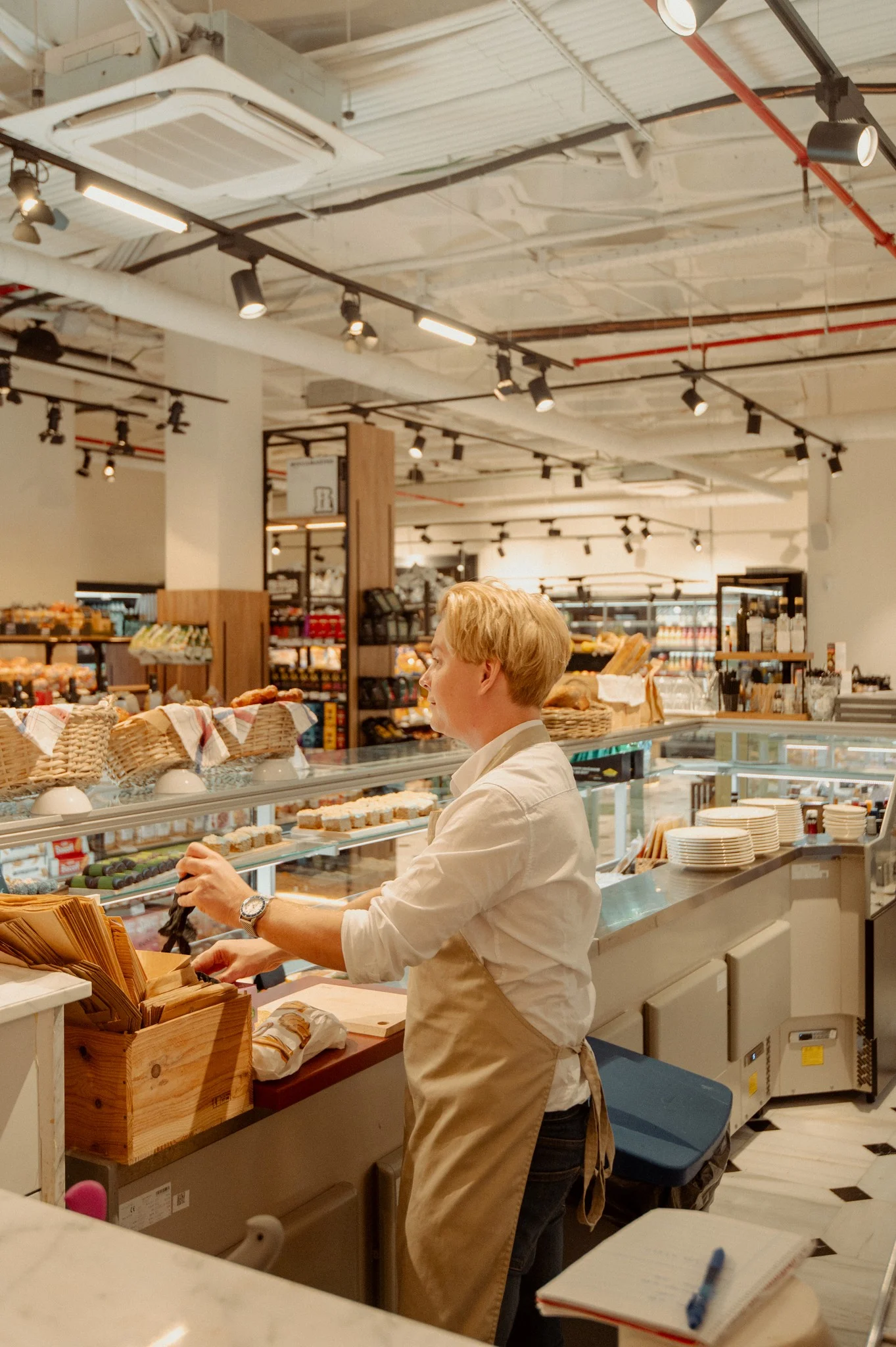 Le comptoir de charcuterie &agrave; l&rsquo;int&eacute;rieur du Baccara Deli & Market, avec les panneaux de menu et le pain frais au Forum Marbella