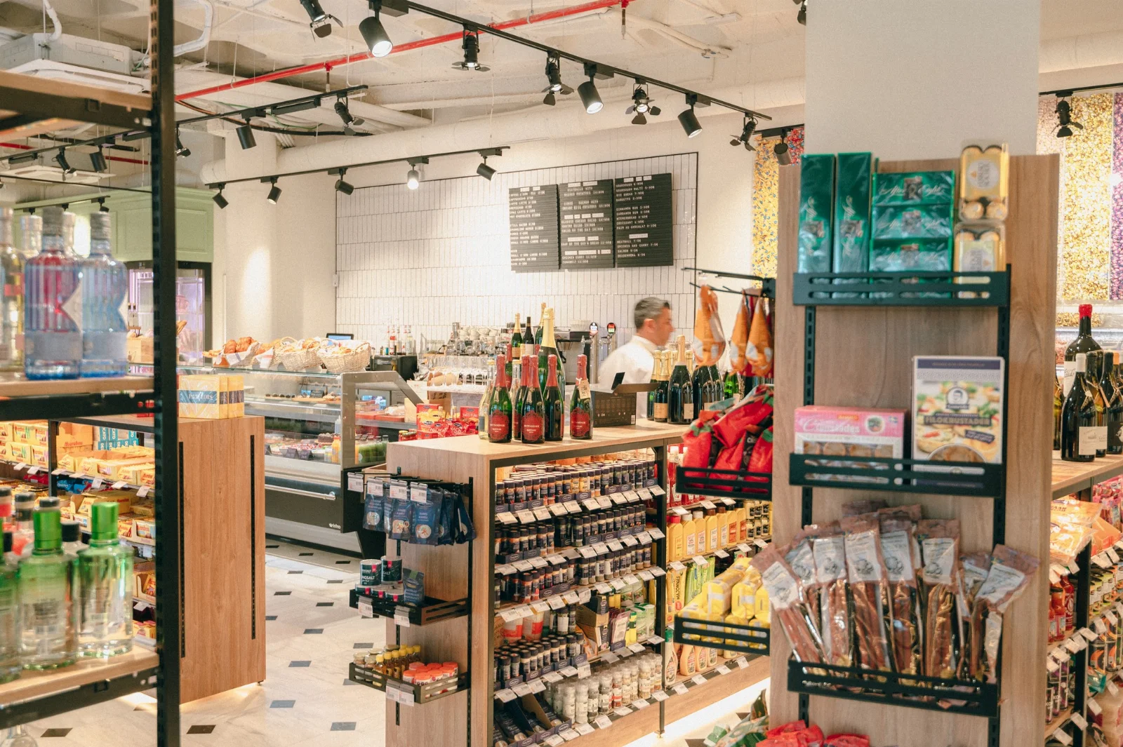 Le comptoir de charcuterie &agrave; l&rsquo;int&eacute;rieur du Baccara Deli & Market, avec les panneaux de menu et le pain frais au Forum Marbella