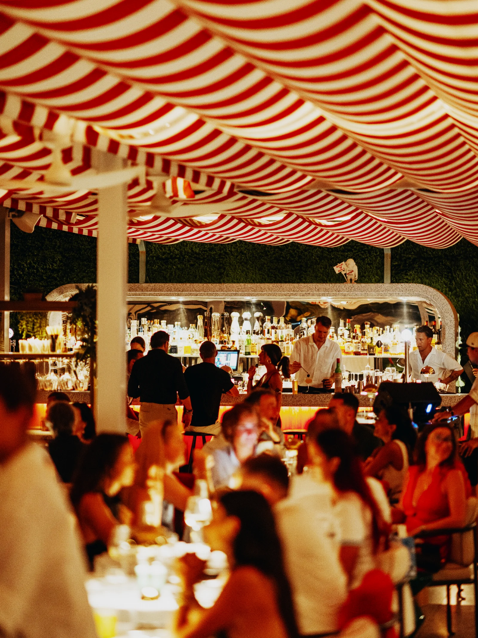 Evening crowd under the red and white striped awnings at Brasserie Astoria Marbella