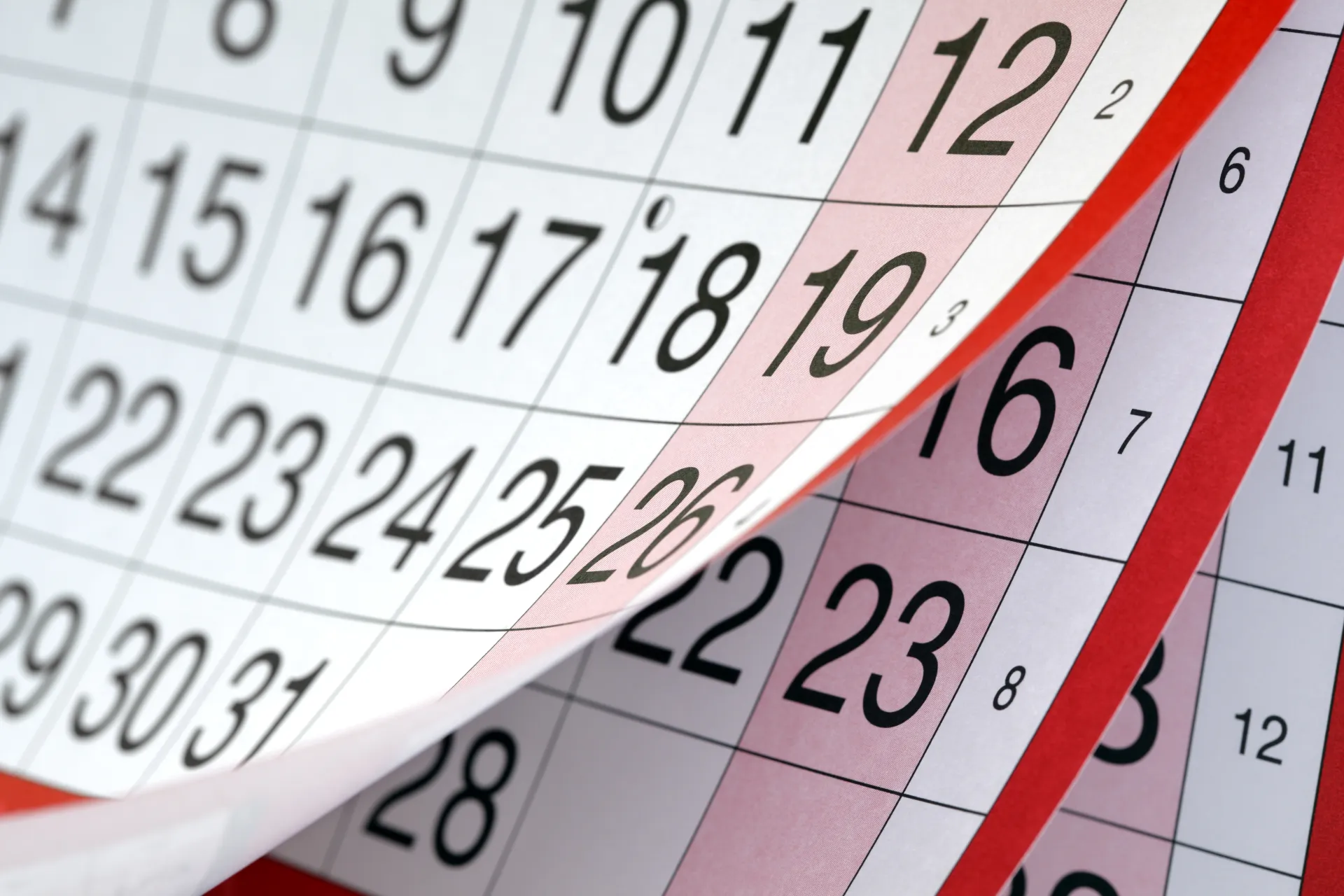 Close-up of wall calendar pages being flipped over