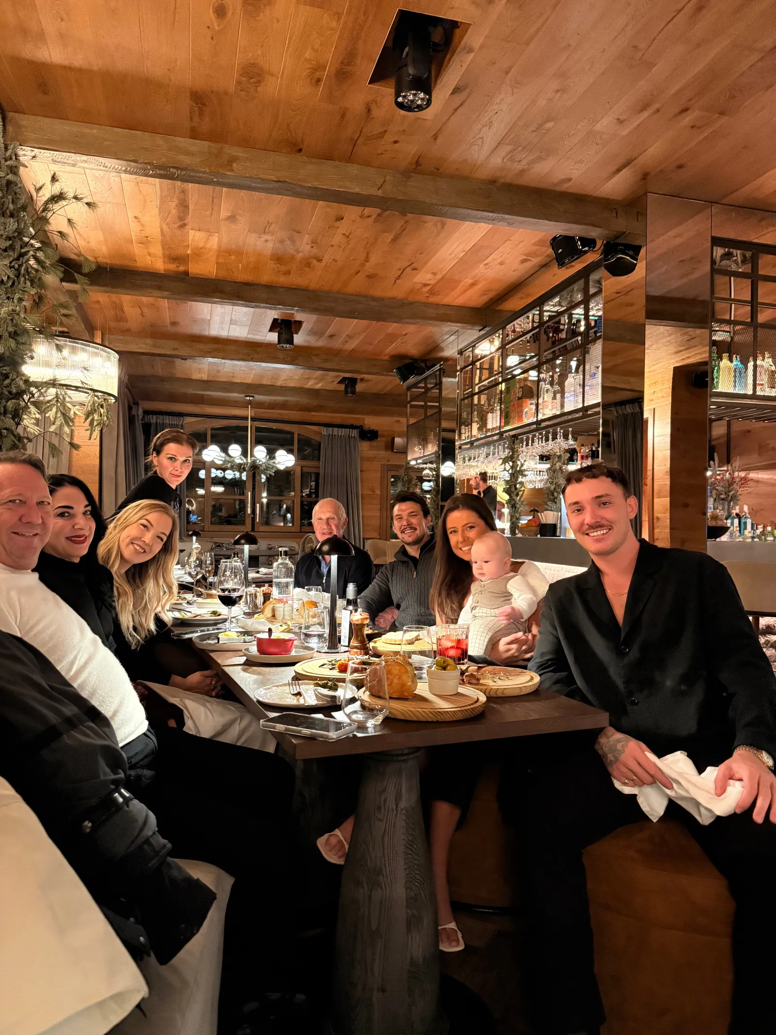 Un grupo de amigos sentados a la mesa en un acogedor restaurante de madera estilo chalet