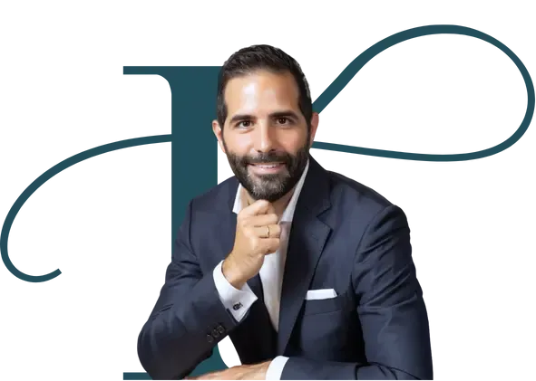 Smiling lawyer in a navy suit posing in front of a teal monogram backdrop